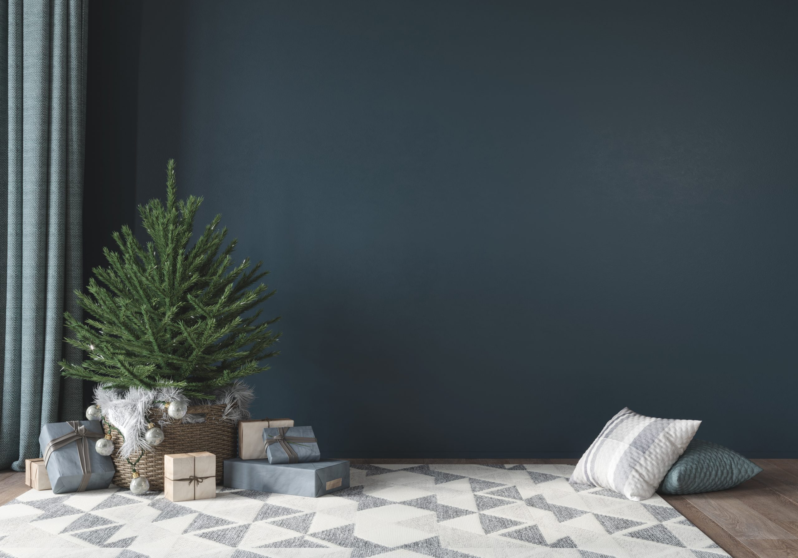 Festive interior with cute little christmas tree in basket, gifts and rug with geometric pattern on blue wall background