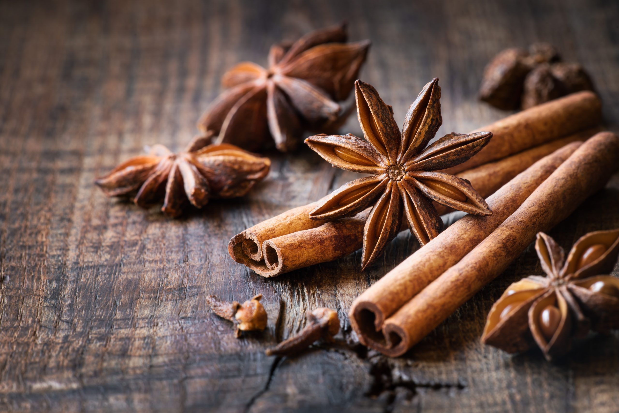 Traditional Christmas spices - Star anise with cinnamon and cloves on dark rustic wooden background